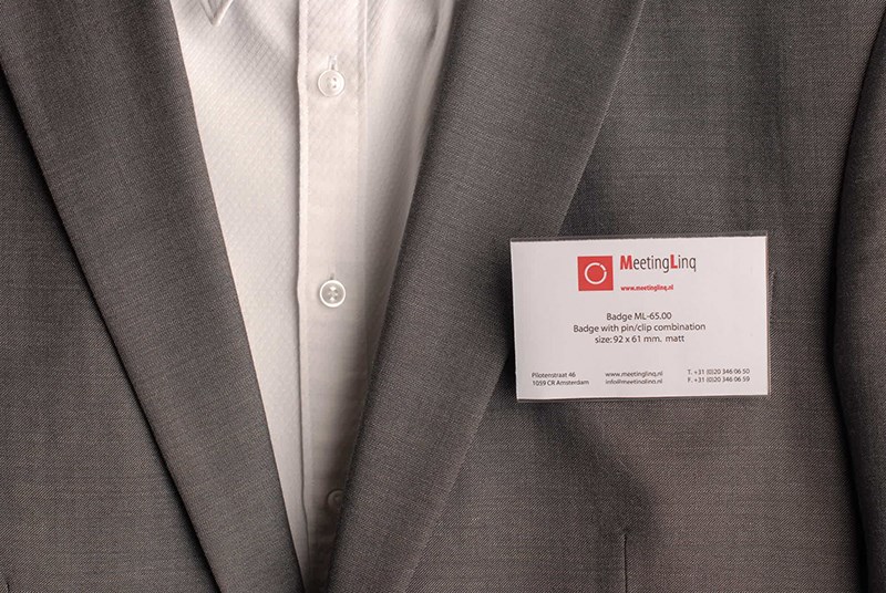 Badge met metalen speld en krokodillenklem.